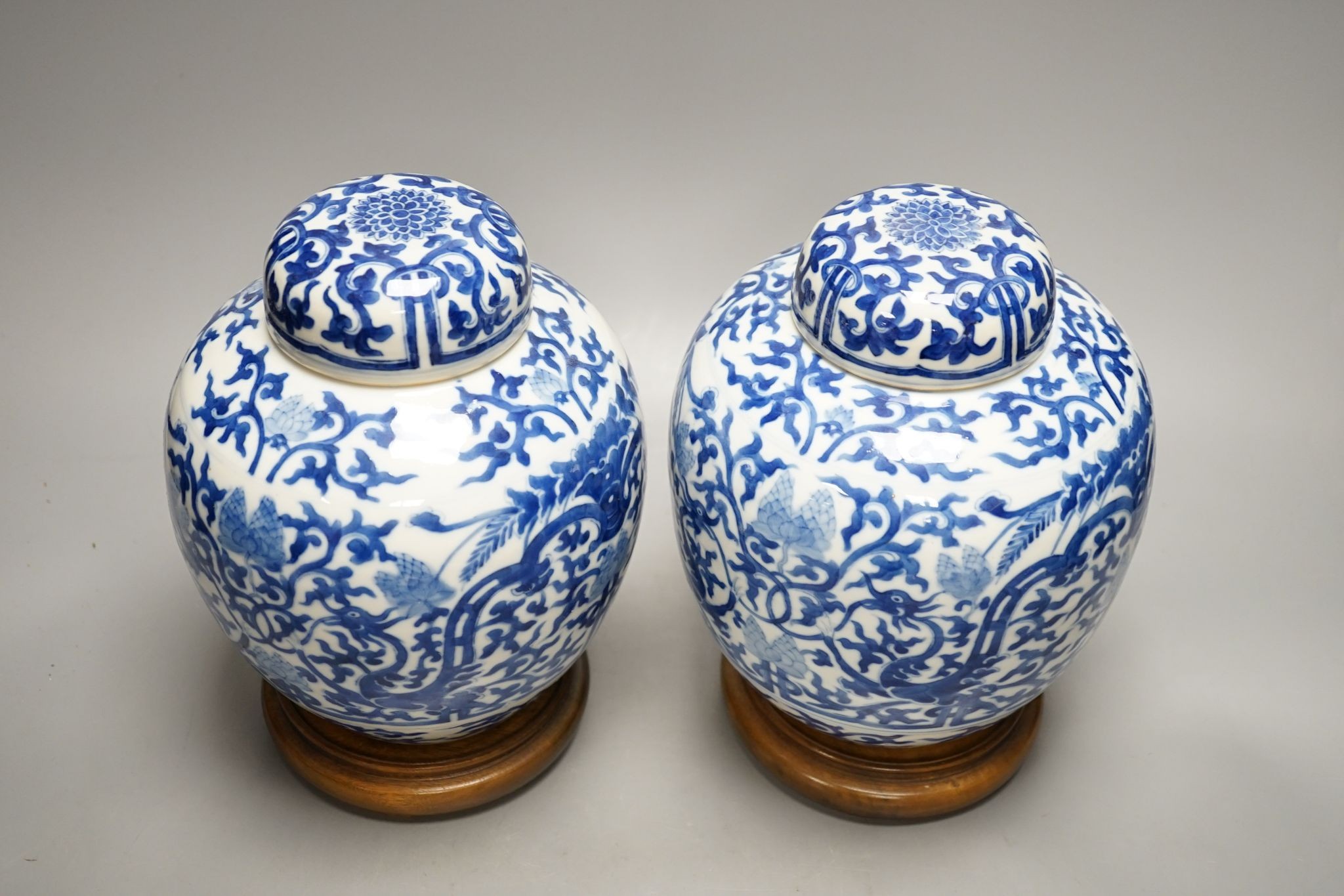 A pair of Chinese blue and white ginger jars and covers, 22cm, On stands